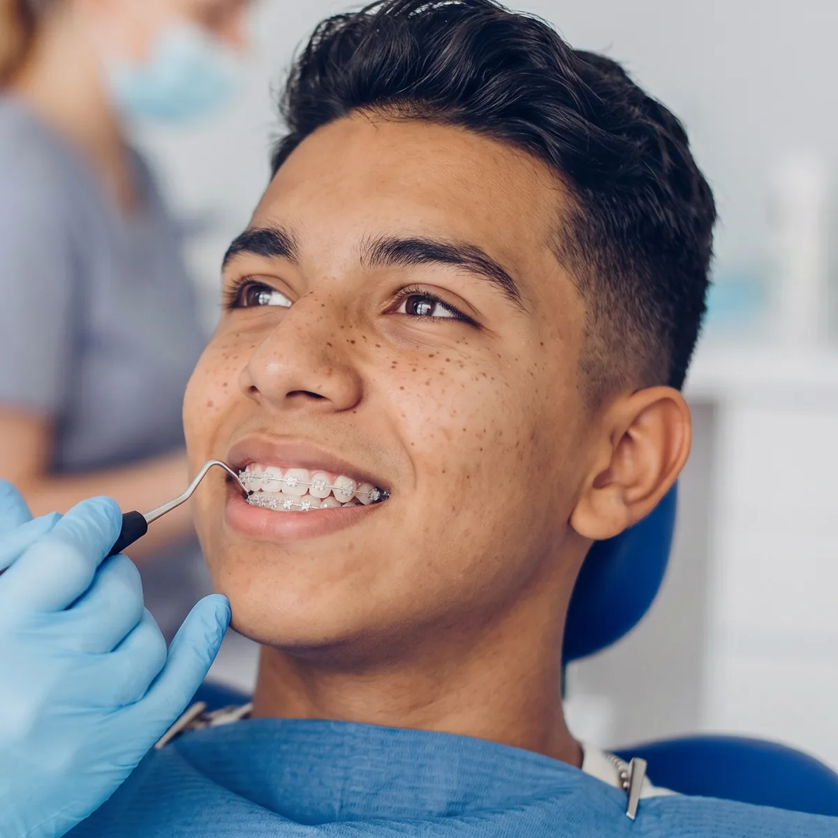 Joven sonriendo con brackets durante su control de ortodoncia