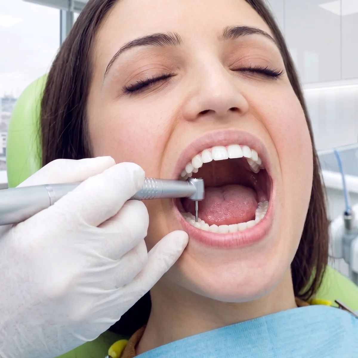Paciente recibiendo un tratamiento dental con pieza de mano en el consultorio